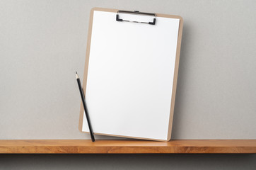front view of A4 paper with clipboard on bookshelf