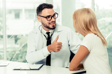 Male doctor is talking with female patient in hospital office. Healthcare and medical service.