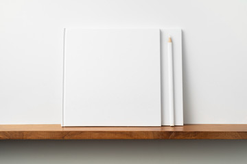 two white square notebook on bookshelf