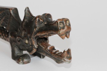 View of a vintage metallic Soviet nutcracker in the shape of a winged dragon with natural patina...