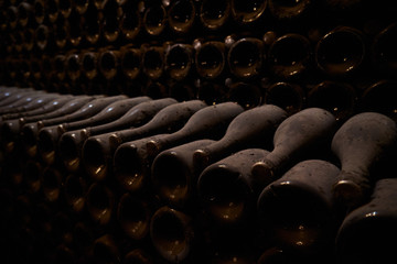 Image of wine bottles in an underground tunnel for aging wine.