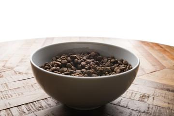 cat food dish - bowl of cat dry food standing on wooden table in front of white background