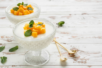 Bowls of delicious panna cotta on white table