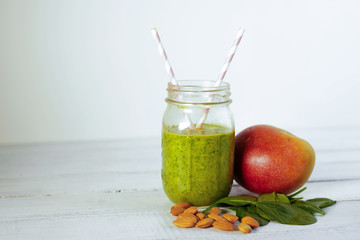Components of healthy Green Reach Vitamins Smoothie with baby leaf spinach, mango, almond milk and strawberry