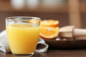 Glass of freshly squeezed orange juice on table