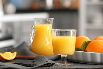 Glass and jug of freshly squeezed orange juice on table
