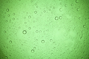 Rain droplets on green glass background, Water drops on green glass.