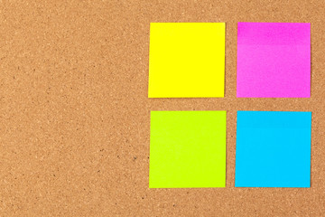 Cork board with several colorful blank notes with pins