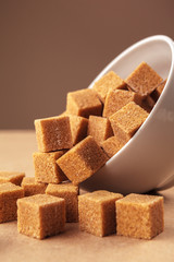 Brown cane sugar cubes on a light brown background