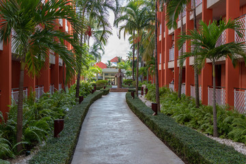 Garden hotel with garden paths, palm trees and a green lawn at sunrise.