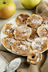 Naklejka na ściany i meble Apple chips with powdered sugar and cinnamon on beige fabric on background whole apples.
