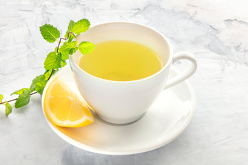 A photo of a cup of tea with lemon and mint with copy space