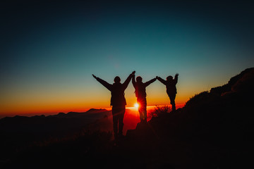 Fototapeta na wymiar Happy father and kids hiking at sunset mountains