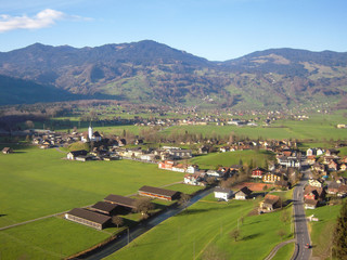 Fototapeta na wymiar ゴールデン・パス・ラインの車窓　秋の中央スイス地方、ギスヴィルの街と教会（スイス・オプヴァルデン準州・ギスヴィル）