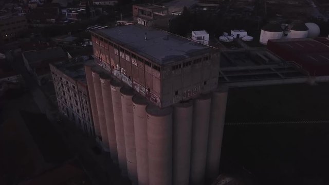 Aerial - Industrial building cylindrical shape infrastructure at dusk