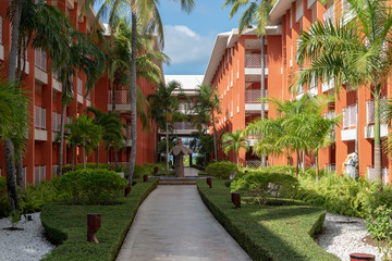 Fototapeta na wymiar Garden hotel with garden paths, palm trees and a green lawn at sunrise.