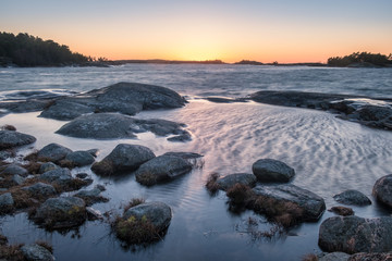 Scenic sea landscape with strong wind and sunset at winter evening in Finland coastline