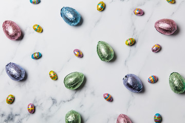 Easter egg chocolate treats wrapped in shiny coloured foil on  marble background