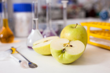 Apples on table on background of lab equipment