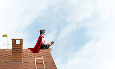 Girl power concept with cute kid guardian against cloudscape background. Mixed media