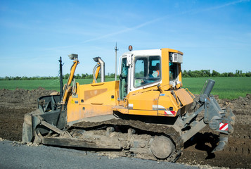 Crawler bulldozer at work to expand the roadway. Side view, Close