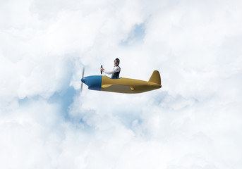Naklejka premium Man in aviator hat driving propeller plane