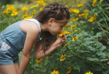 Fototapeta premium portrait of happy beautiful girl in flowerbed