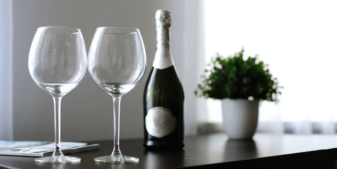 empty glasses and a bottle of wine or champagne on the table at