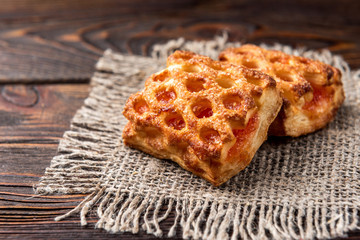 Puff pastry with apple on dark wooden background.