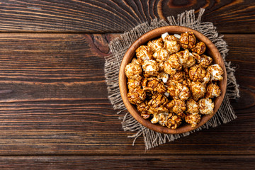 Popcorn on dark wooden background.