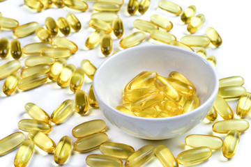 Close up of Fish oil capsules background view. Omega 3. Vitamin E. Supplements food for good health on white background. Salmon.