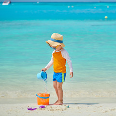 Three year old toddler playing on beach