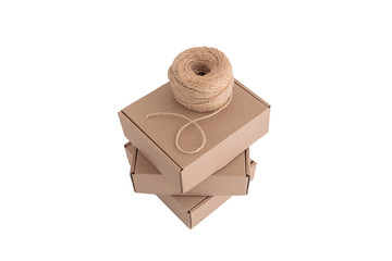 Stack of craft paper boxes and coil of rope isolated on white.