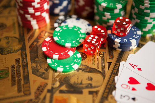Casino red dices and casino poker chips on golden US Dollar bills