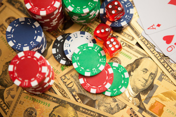 Casino red dices and casino poker chips on golden US Dollar bills