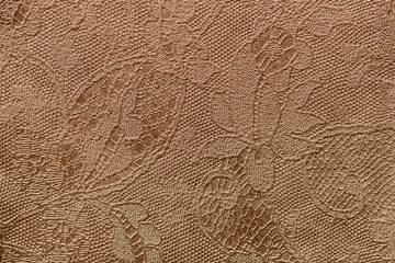 Texture of fragment genuine leather with an abstract floral ornament close-up. Vintage golden...
