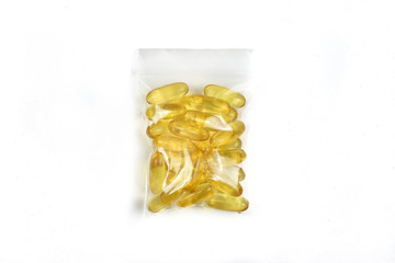 Top view of Fish oil capsules isolated in plastic zipper bag. Omega 3. Vitamin E. Supplements food for good health on white background. Salmon capsules.