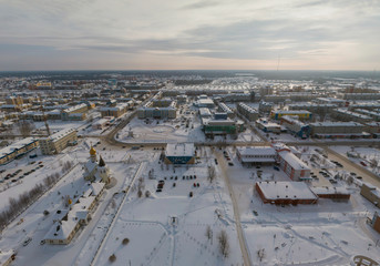 Church and city administration building  in Yugorsk city. Aerial. Winter, snow, cloudy. Khanty Mansiysk Autonomous Okrug (HMAO), Russia.