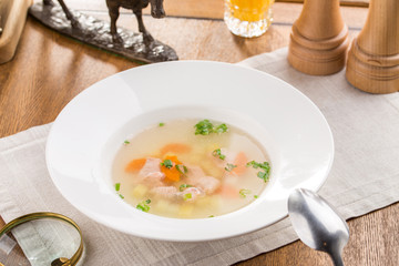 Fresh fish soup with salmon and orange drink on wooden table