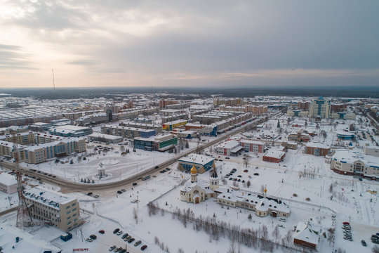 Church and city administration building  in Yugorsk city. Aerial. Winter, snow, cloudy. Khanty Mansiysk Autonomous Okrug (HMAO), Russia.