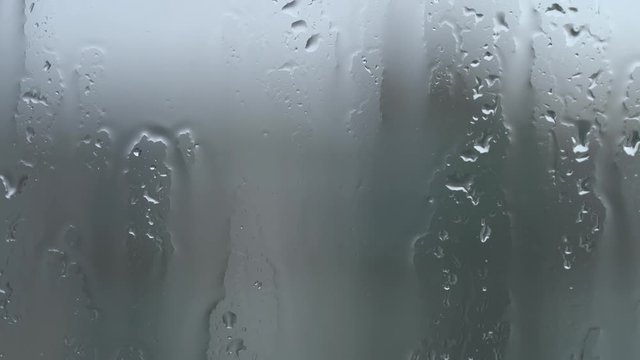 Raindrops on glass of window. 4k video footage.