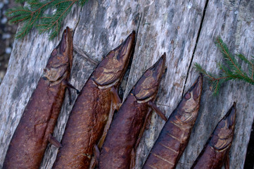 Fototapeta na wymiar Smoked pike on wooden background close up of visas on top, only fish heads