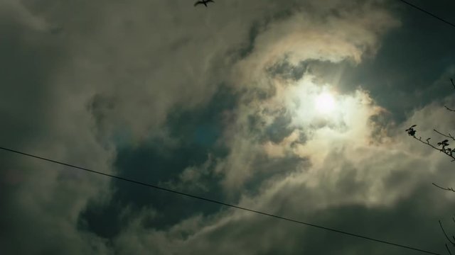 A moody, dark time lapse, the sun peaks out from behind the dark clouds.