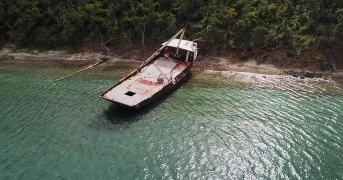 Aerial Pan Left to Right: Old Boat Wrecked in the Shoreline of Norman Island in Norman Island, British Virgin Islands