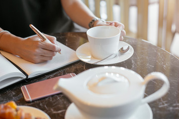 Taking notes while drinking tea. 