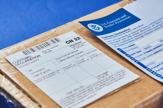 Customs Declaration Form lies on Parcel with Customs declaration form CN22 on a blue velvet background. Close-up.