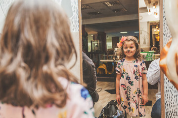 Portrait of funny little girl with face painting at birthday party