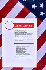 Page with the rules of customs clearance on American flag background. Close-up