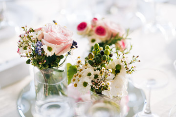 Two bouquets of colored flower in glass vases