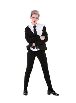 Attitude woman with a suit, shirt and tie, isolated, full body on white background. The masculine girl has short blonde hair and suit jacket bunched up off her shoulders in a messy, yet stylish way